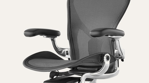 An Aeron chair with black frame and pellicle, chrome metal accents, and lumbar support.