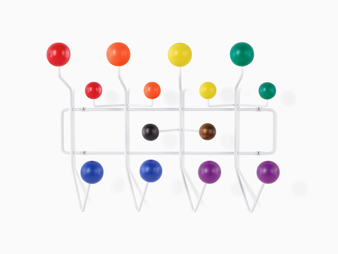 An Eames Pride Hang-It-All, showing a white wire frame and rainbow-colored knobs