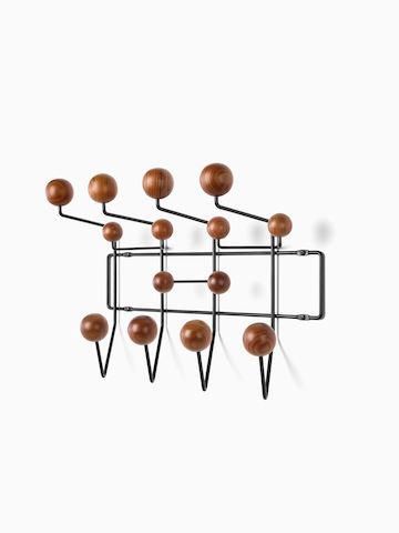 An Eames Hang-It-All storage rack with wood knobs. Select to go to the Eames Hang-It-All product page.