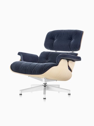 An Eames Lounge Chair with blue mohair upholstery and a white ash veneer shell, viewed from a 45-degree angle. 