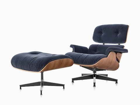 Eames Lounge Chair and Ottoman with blue mohair upholstery and a wood veneer shell, viewed from a 45-degree angle. 