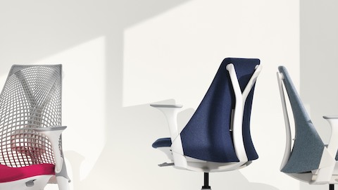 Three Sayl office chairs, one white with suspension back, one blue with upholstered back, and one light gray with upholstered back.