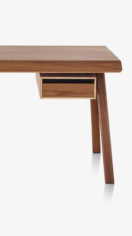 Partial view of a Distil Desk with a medium woodgrain finish. Select to see desks available from the Herman Miller Store.