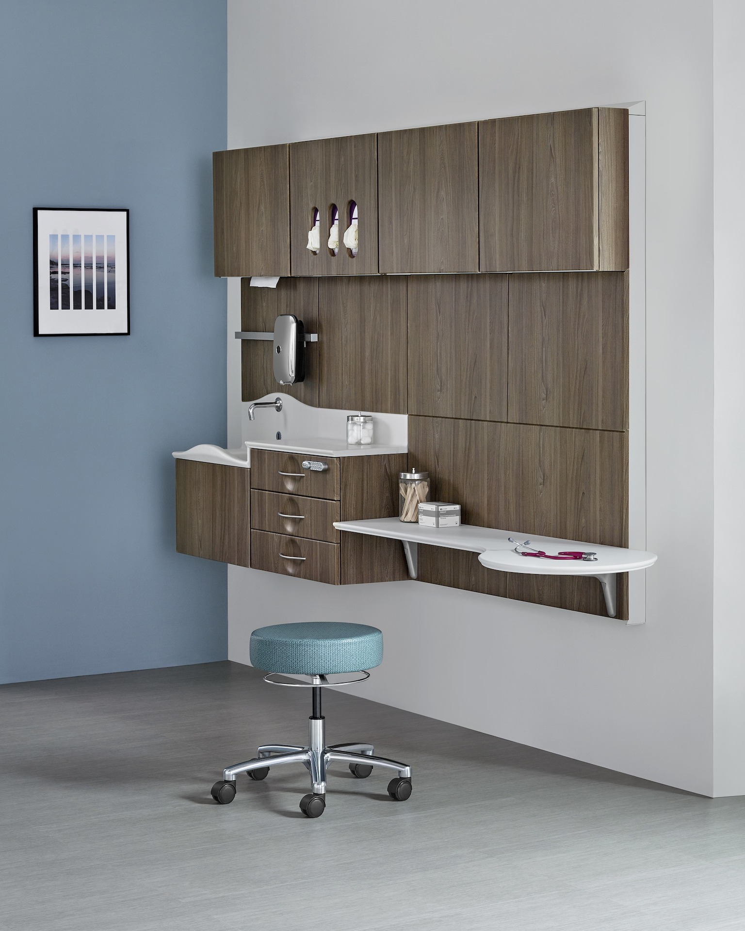 An exam room featuring a dark wood laminate Compass System and a blue stool on casters.