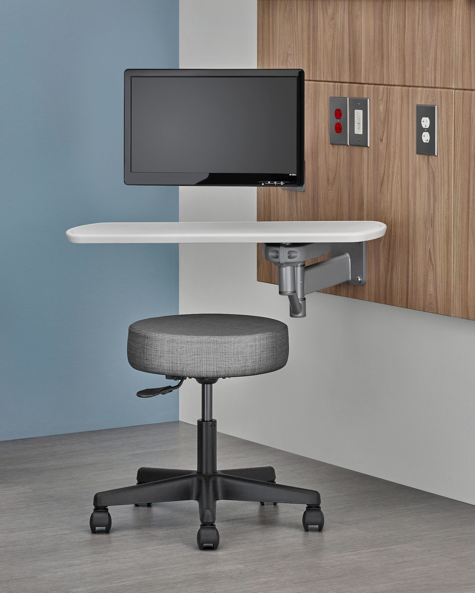 Close up of a rotating work surface as part of the Compass System. A gray Physican Stool sits in the foreground.