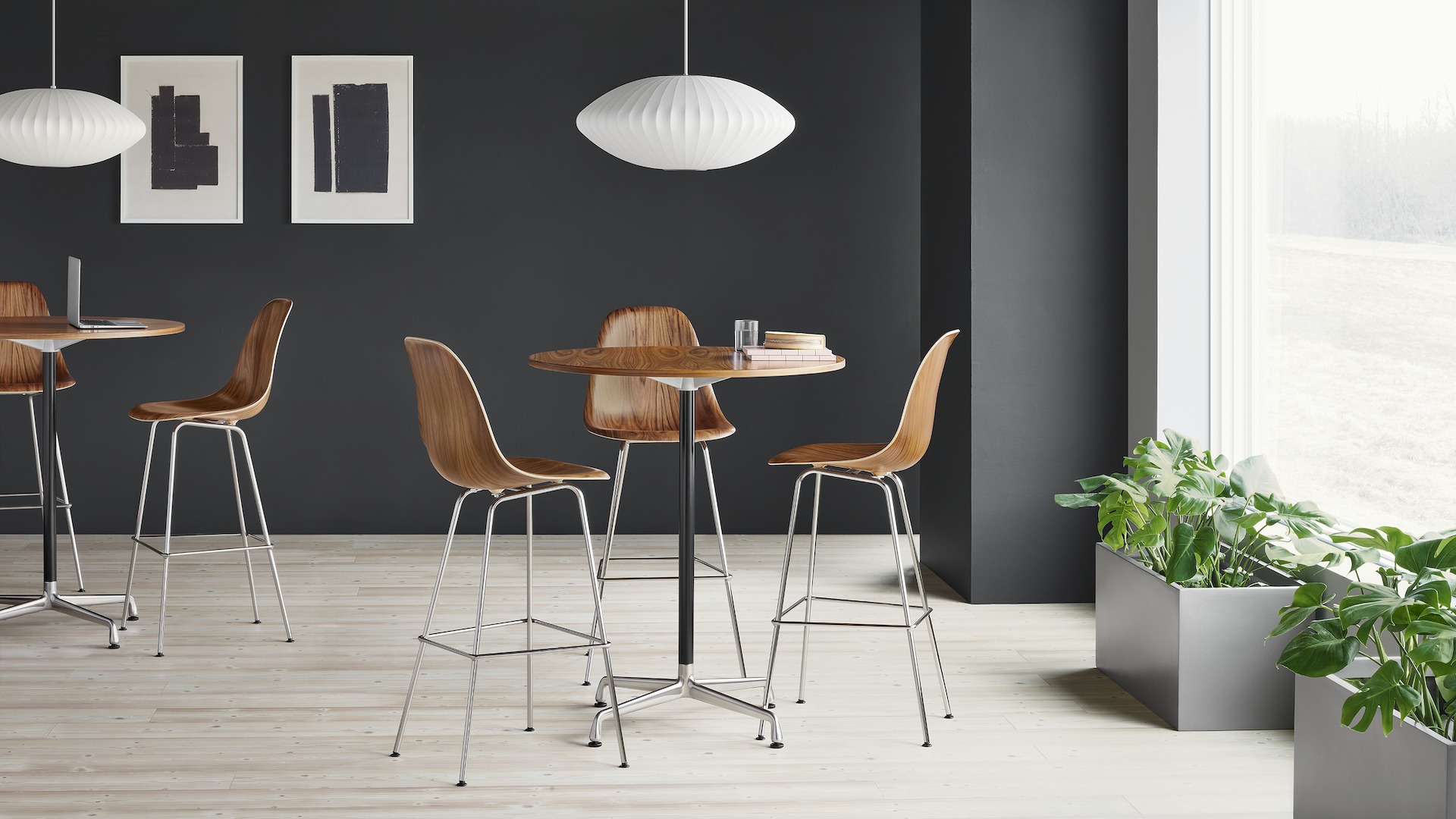 Three Eames Molded Wood Stools in santos palisander around an Eames standing height table with a santos palisander surface.