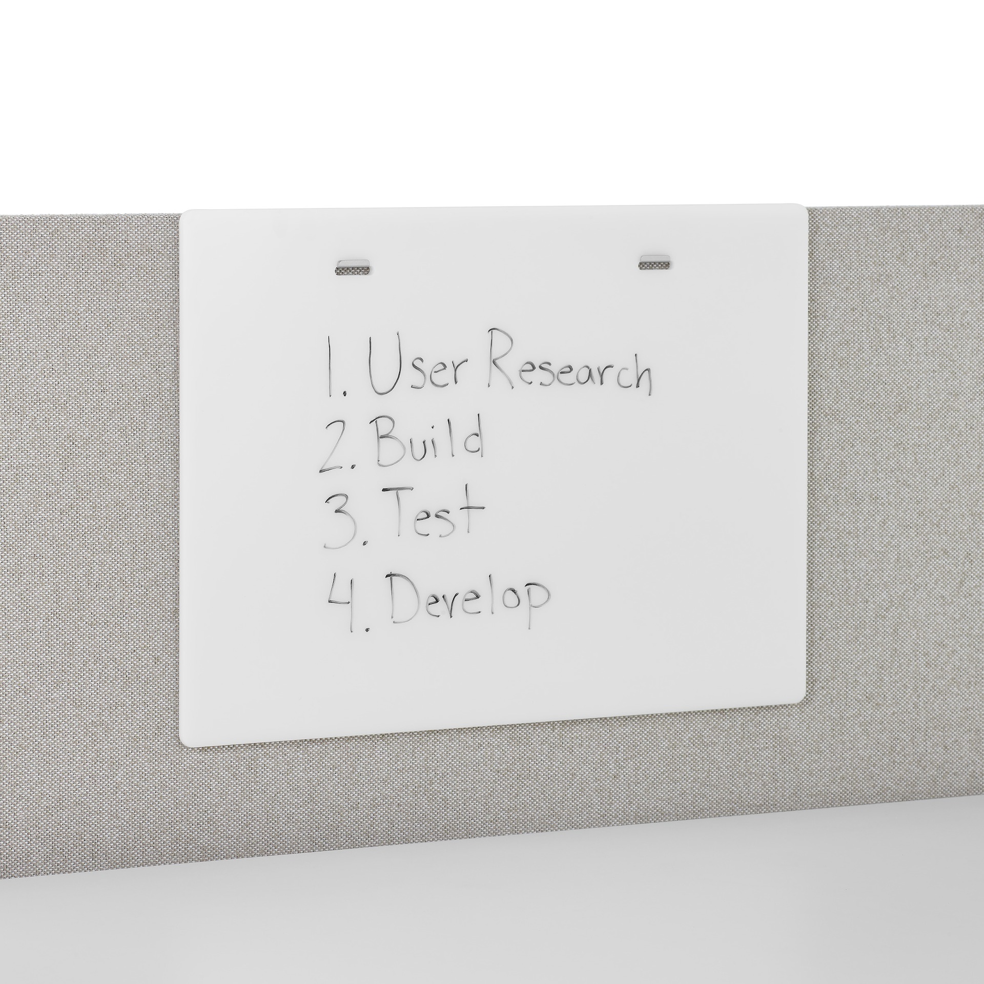 A white, acrylic marker board, with writing on it, attached to a gray privacy screen.