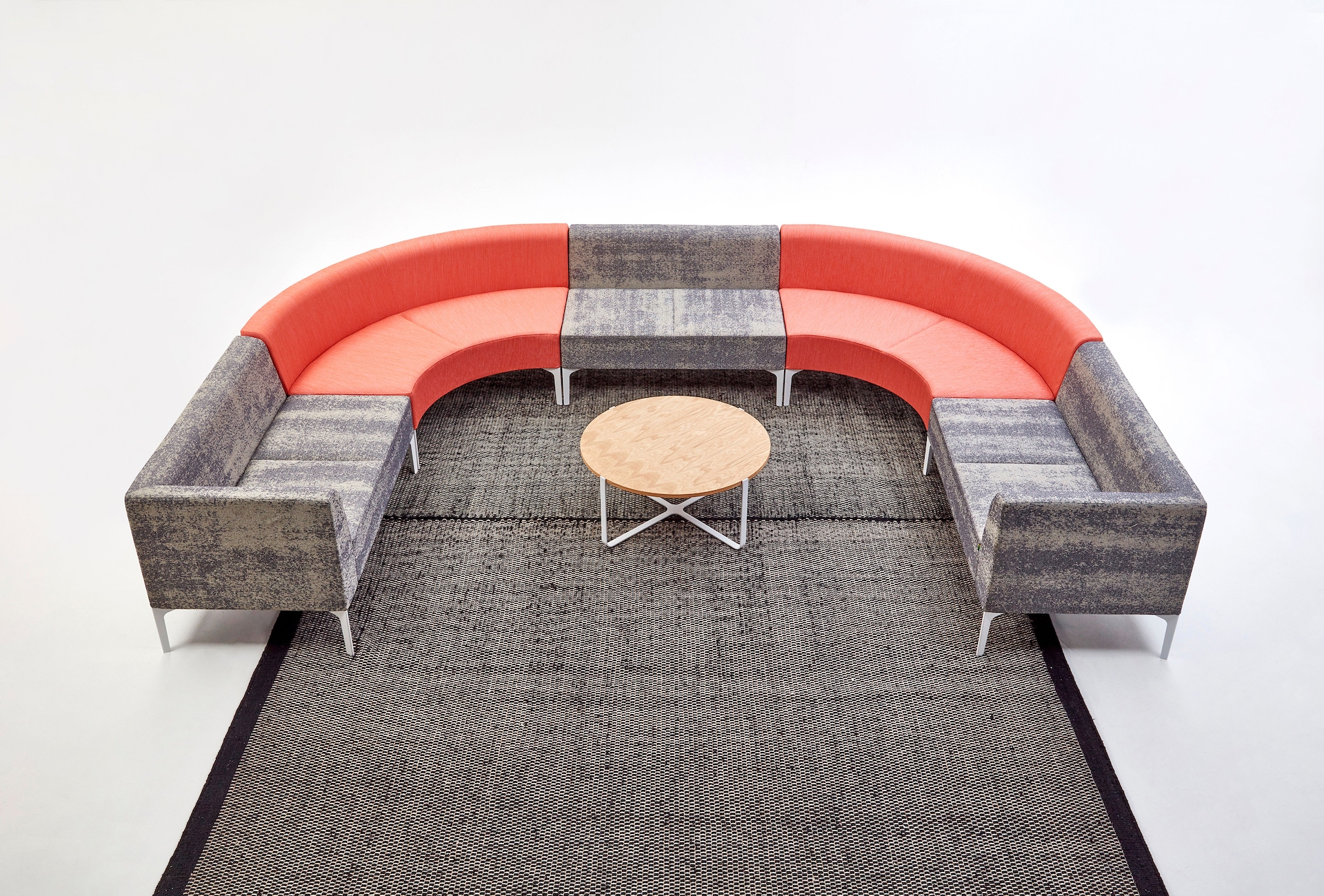 Naughtone Symbol Modular Seating arrangement containing gray patterned pieces along with orange 90 degree pieces.