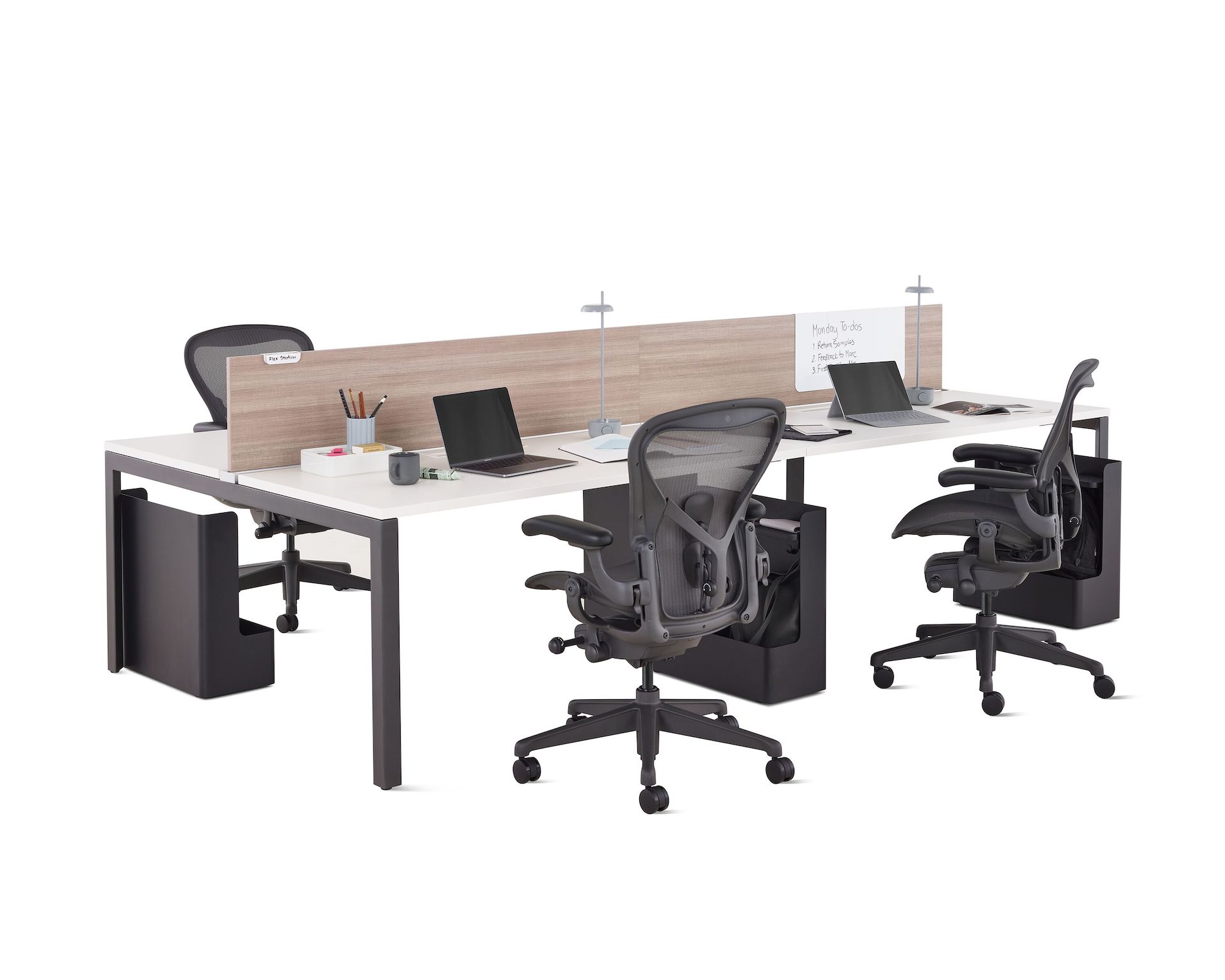 Layout Studio benching workstation with gray woodgrain laminate center screens, Ubi bag storage, desk organizers, and four graphite Aeron chairs.