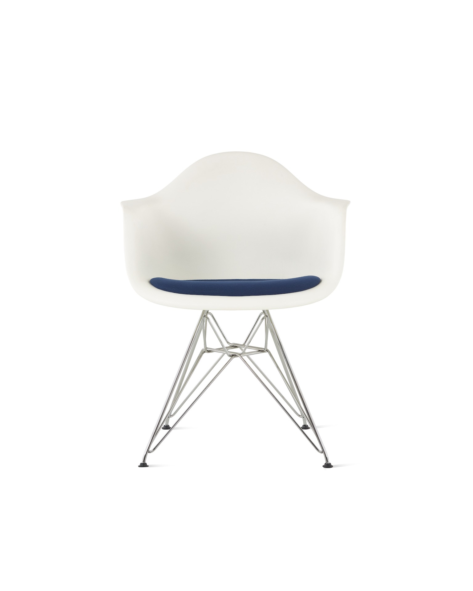 A white Eames Molded Plastic Armchair with navy seat pad and wire base.