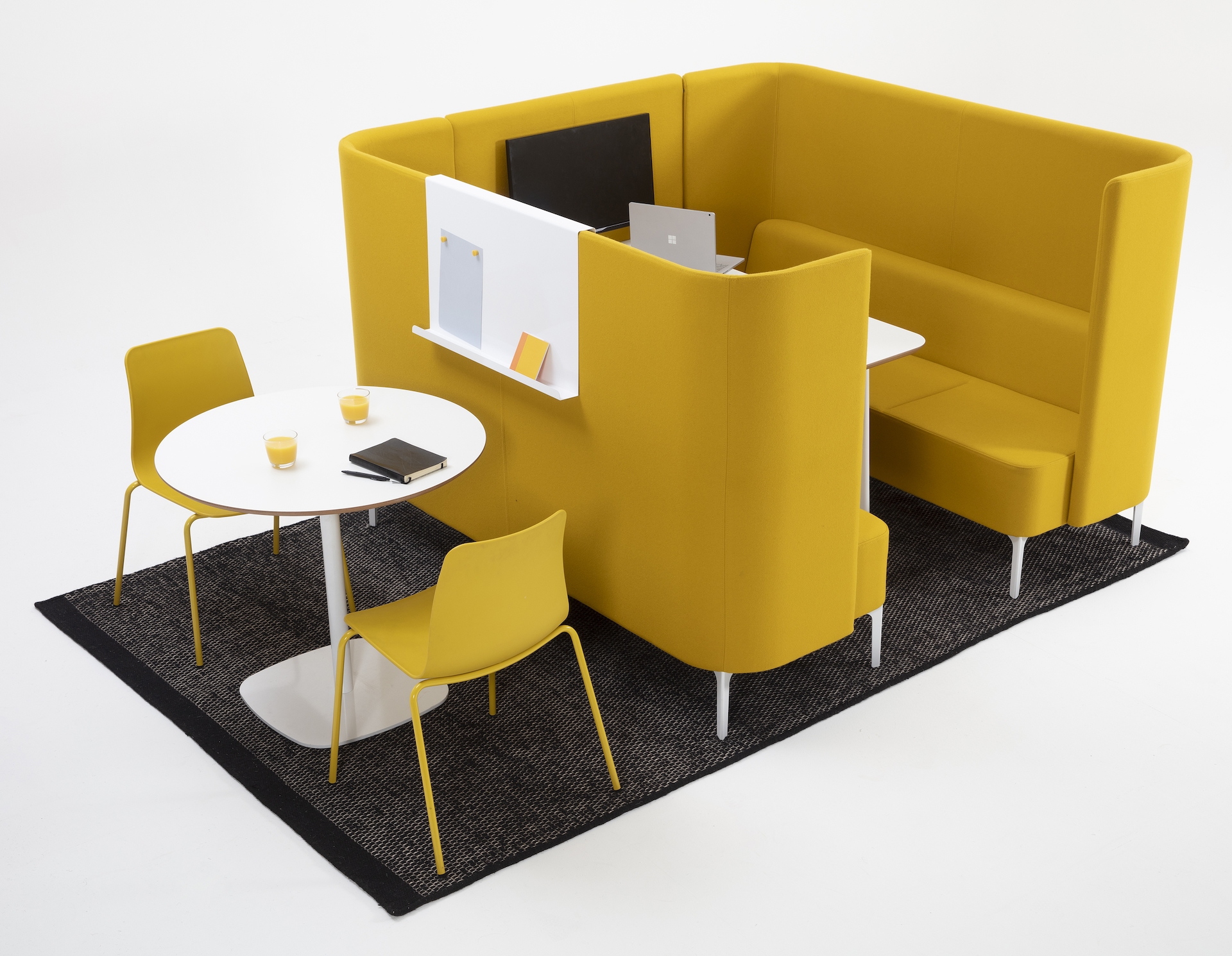 6 seat Pullman Booth upholstered in yellow fabric, with white metal feet and white mfmdf table top and tv screen. Sat next to two yellow polypropylene Polly Chairs with white cafe table.