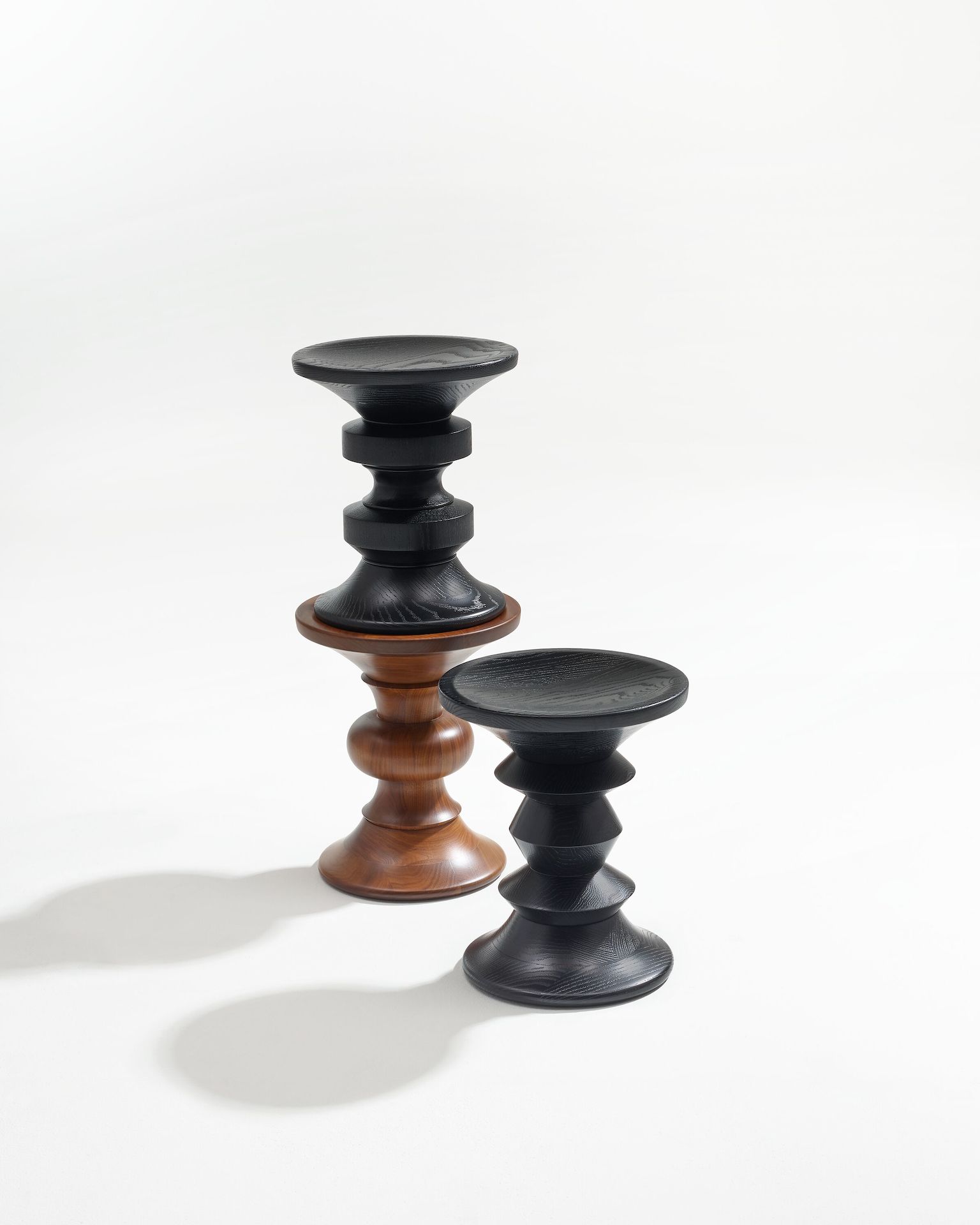 Eames Turned Stool Shape B in Walnut, Shape C and D in Ebony.