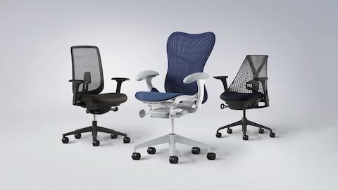 Drie ergonomische stoelen van Herman Miller gefotografeerd in een studio. 