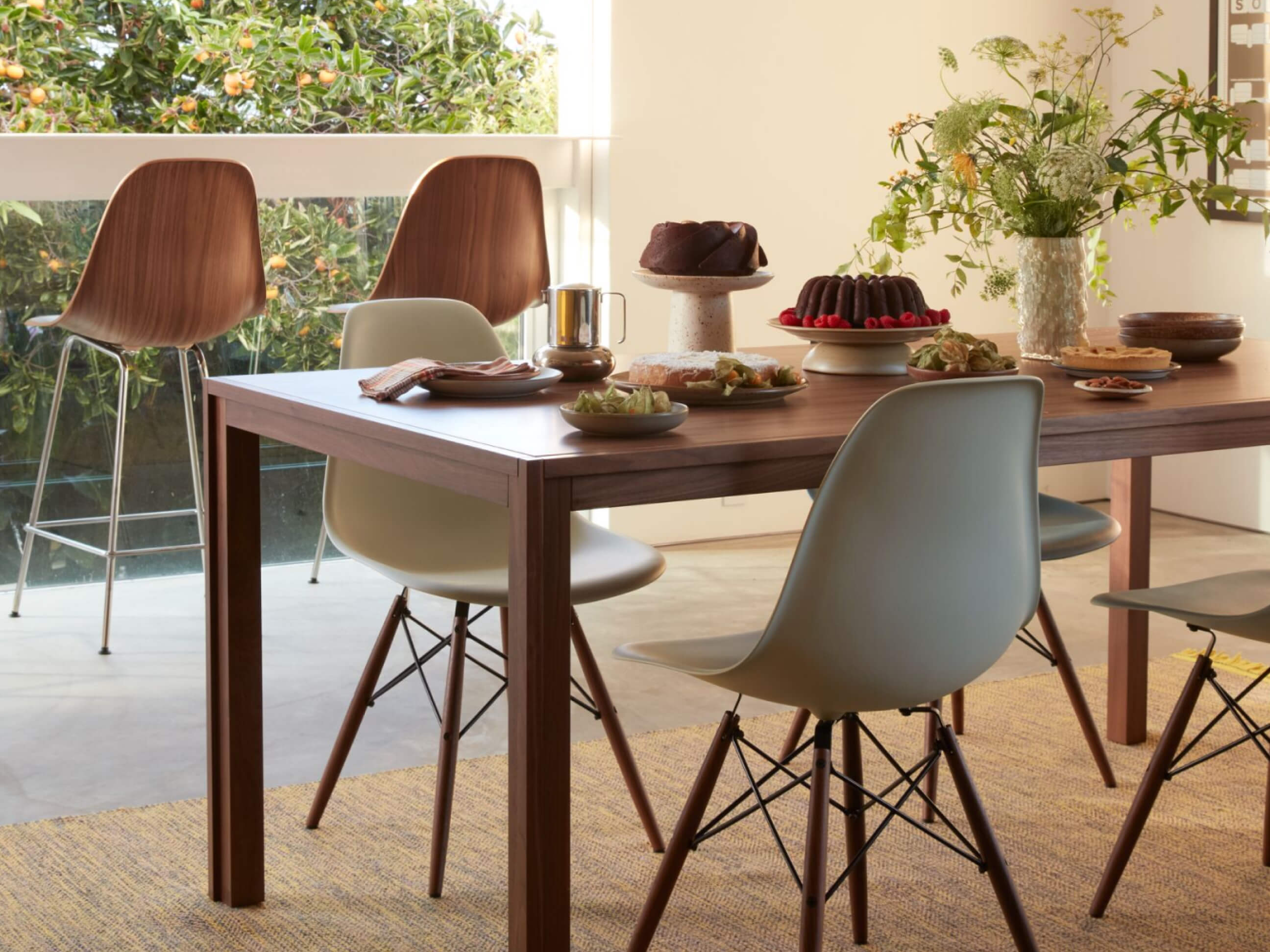 Shown in plastic and molded plywood, the iconic Eames Shell Chair completes a summer evening.