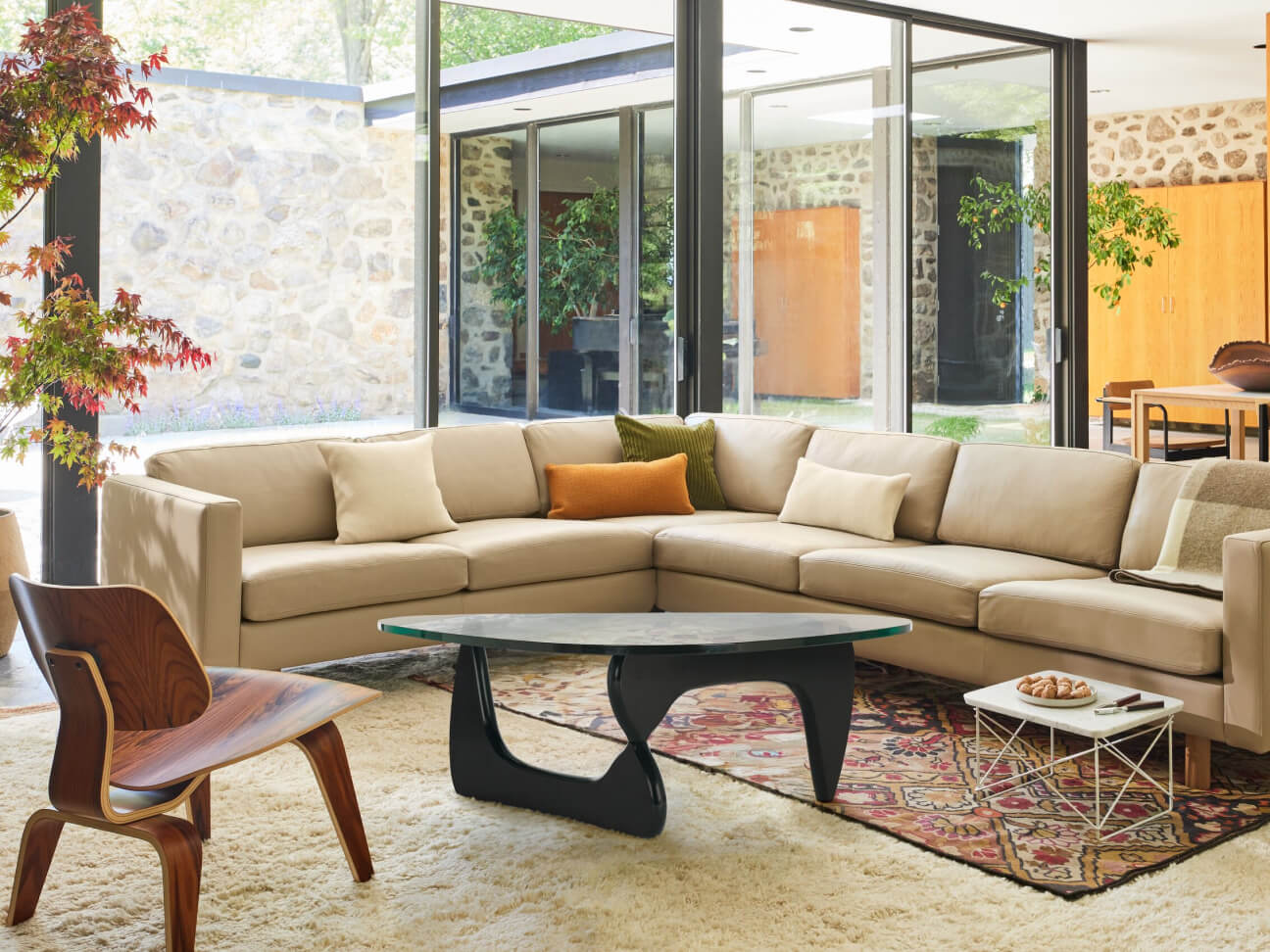 a modern living room with the Lispenard Sofa Sectional in the background and a Noguchi Table in the foreground.