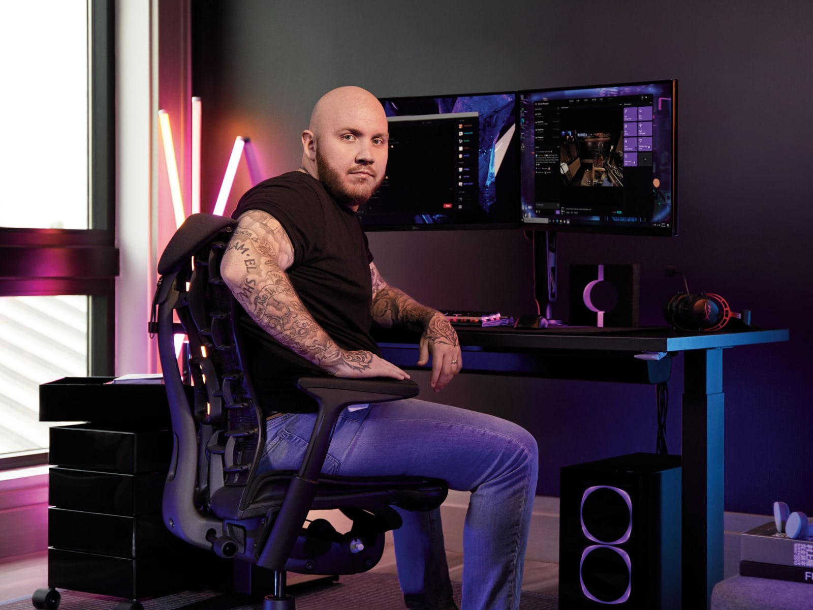 Em seu espaço de jogos, o streamer Pro Timthetatman está sentado em uma cadeira Embody Gaming, uma mesa Herman Miller com altura ajustável e com dois braços de monitores.