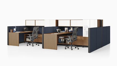 Dos estaciones de trabajo Canvas Wall en madera oscura con paneles azules, almacenamiento superior blanco y sillas para oficinas Cosm negras.