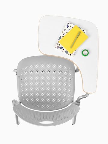 Vista superior de la silla Caper gris claro con un asiento moldeado y un brazo para tableta.