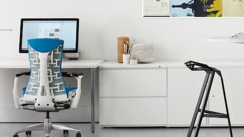 White Tu Armários de armazenamento e arquivos laterais mostrados com uma cadeira de escritório azul Embody em uma estação de trabalho aberta.