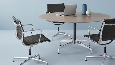 由Eames Aluminum 组合椅围绕的Eames表。选择进入Eames Tables产品页面。