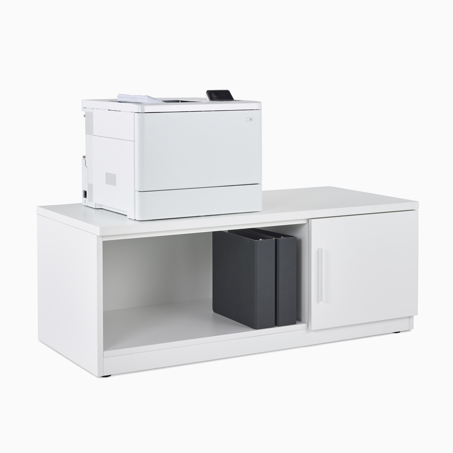 Almacenamiento de impresora Mora System con dos cubículos, uno abierto con dos archivadores negros y uno cerrado, con una impresora sobre el espacio de almacenamiento.