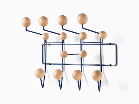 Angled view of an Eames Hang-It-All storage rack, featuring a dark blue wire frame and wood knobs in a light finish.