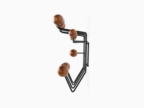 Profile view of an Eames Hang-It-All storage rack, featuring a black wire frame and wood knobs in a medium finish.