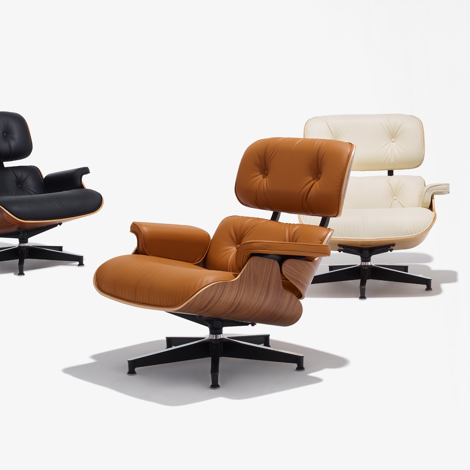 Eames Lounge Chairs in black, russet, and ivory bamboo upholstery. 