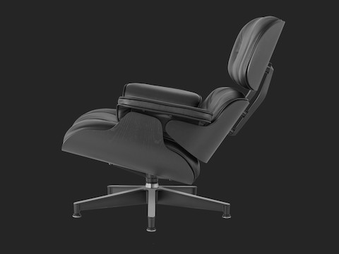 Profile view of a black leather Eames Lounge Chair with a black shell. 