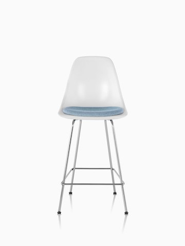 白色Eames模压玻璃纤维凳子，从正面看，带浅蓝色座垫。
