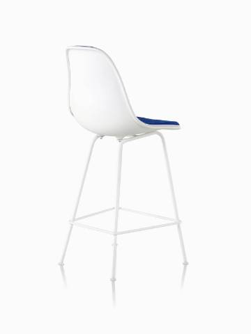 一个白色的Eames四分之三后视图与蓝色室内装饰塑料塑料凳子。