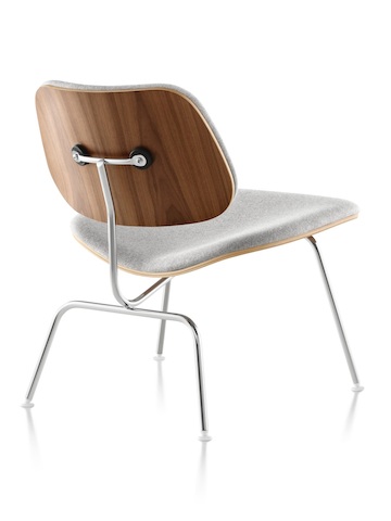 Vista trasera de tres cuartos de una silla de contrachapado moldeada Eames tapizada en gris con patas cromadas.