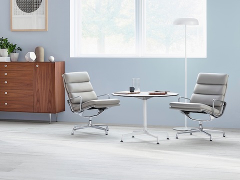 带有白色上衣的Eames圆桌，配以两款浅灰Eames Soft Pad椅子。