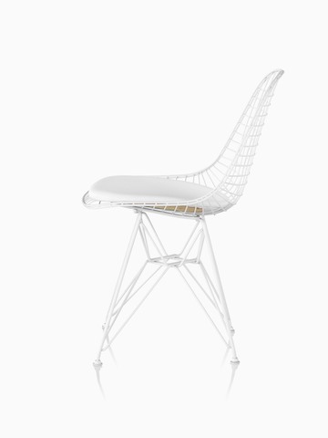 Vista de perfil de uma cadeira lateral Eames Wire com uma base de assento em couro branco e base de arame.
