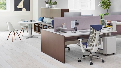展示蓝色Embody办公椅，木制贴面Renew Link办公桌和白色Eames模塑塑料椅的工作环境。