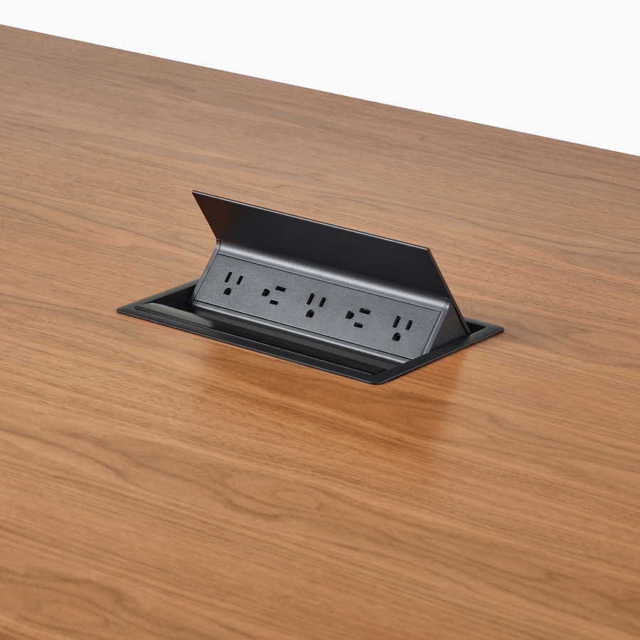 A close-up view of Logic power access installed in the surface of a Headway conference table.