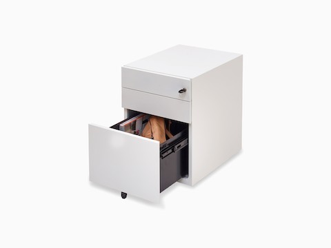 Angled view of white Kumi pedestal with opened file drawer showing purse and magazine stored inside.