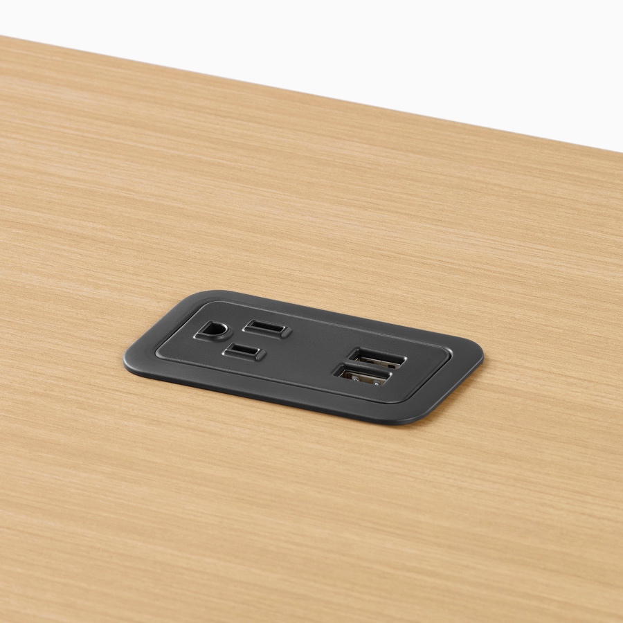 Close-up image of a black power outlet mounted within a wood Canvas Vista surface.