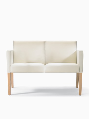 A front view of a Brava 862 Settee in white textile with fully upholstered arms and maple legs.