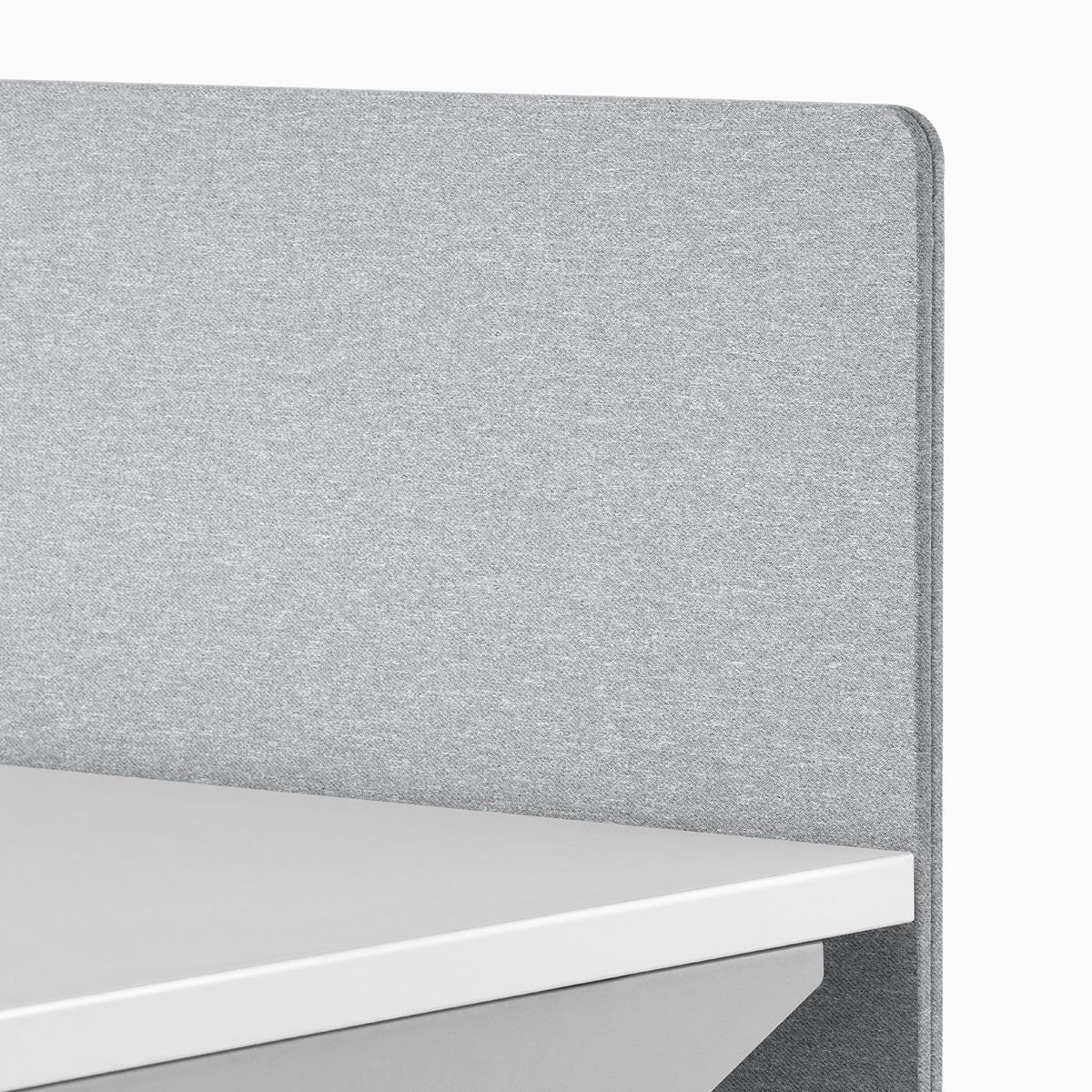 A close-up view of a gray fabric screen attached to the surface of a Nevi standing desk.