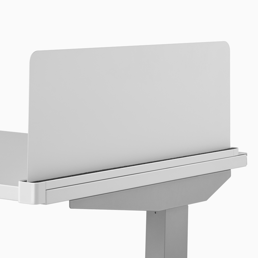 A close-up view of a gray Ubi screen attached to the side of a Nevi standing desk's surface.