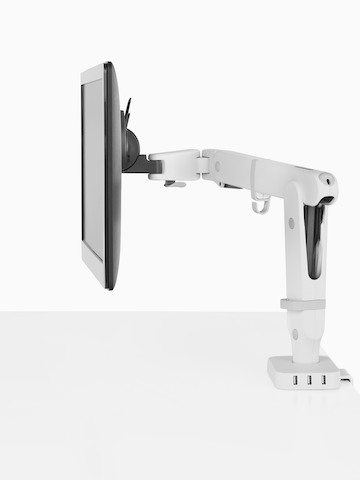Vista de perfil de um monitor suportado por um braço do monitor Ollin que está conectado a um Flo Power Hub com três portas USB.