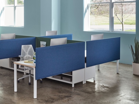 A blue Pari Screen provides seated privacy for a workstation featuring a white Sayl office chair.