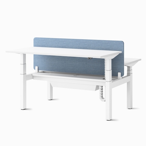 Two Ratio height adjustable desks, positioned at seating and standing heights, back to back with a frameless, blue mounted privacy screen and a high capacity tray.