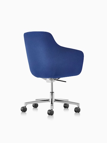 Vista posteriore a tre quarti di una sedia da ufficio con schienale medio Saiba in tessuto blu con una base a cinque razze lucida e ruote.
