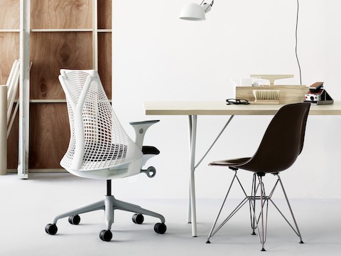 白いSaylオフィスチェア、黒いEames製ワイヤーベース付きガラス繊維製椅子、Nelson X-Leg Table付きの小規模オフィス。