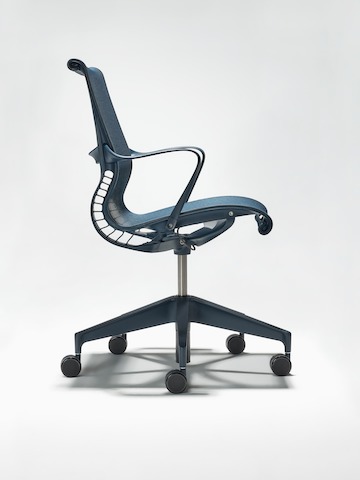 Side view of a Setu Chair with arms in nightfall blue.