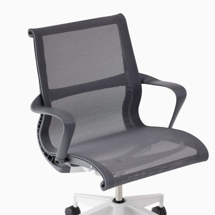 A close-up view of a Setu chair with arms in grey.