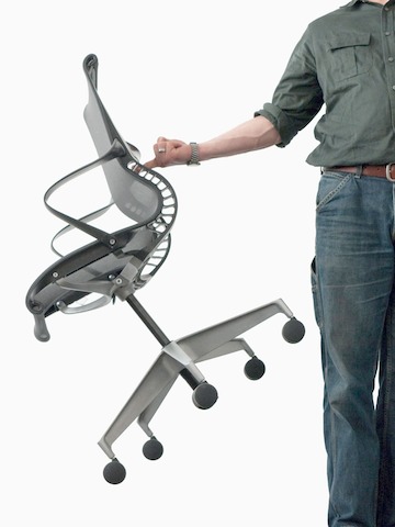 A man lifting a Setu Chair with his finger.