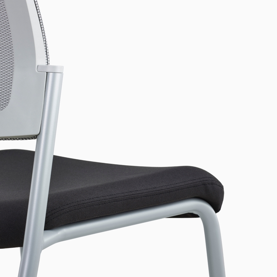 A close-up view of a grey Verus Side Chair's black upholstered seat with no arms.